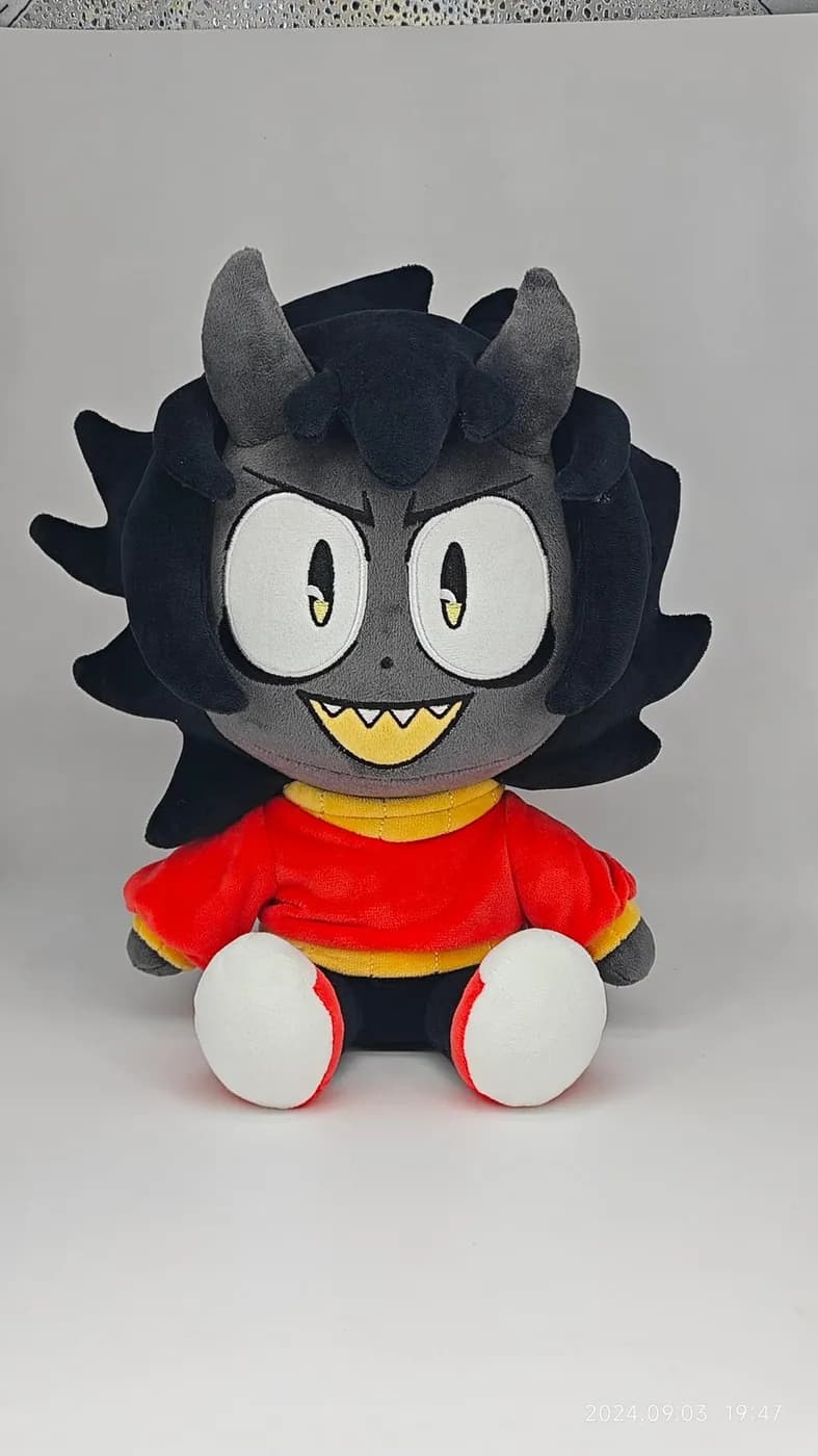 Black-haired character plush with large appliqué eyes and a red top