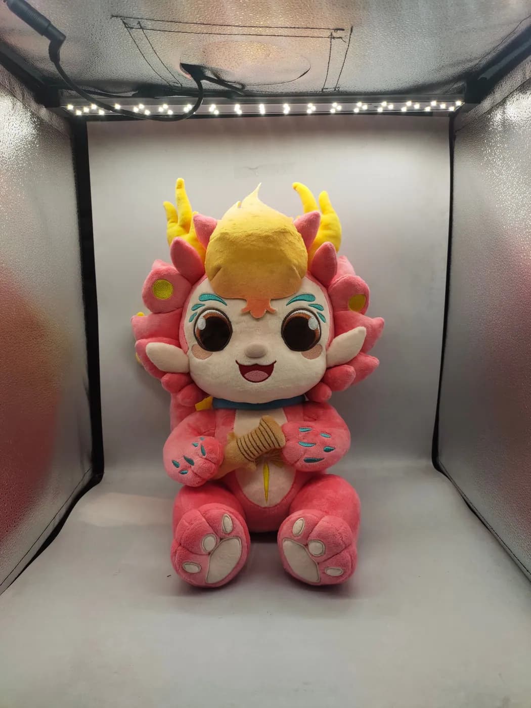 Pink dragon plush toy photographed in the sample lightbox