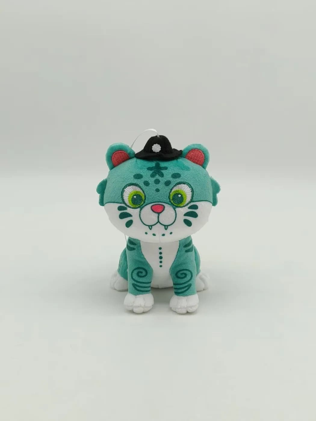 Teal tiger plush toy with printed markings and an embroidered face