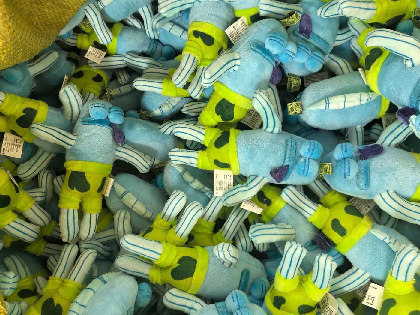 Bulk run of lime and pale blue character charms with hangtags attached