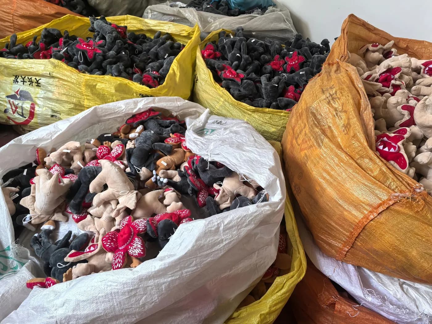 Sacks of finished plush charms waiting for inspection
