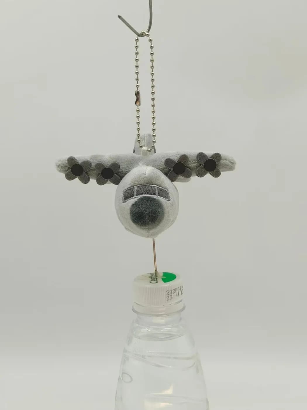 Aircraft plush charm seen from the front, hung on a ball chain
