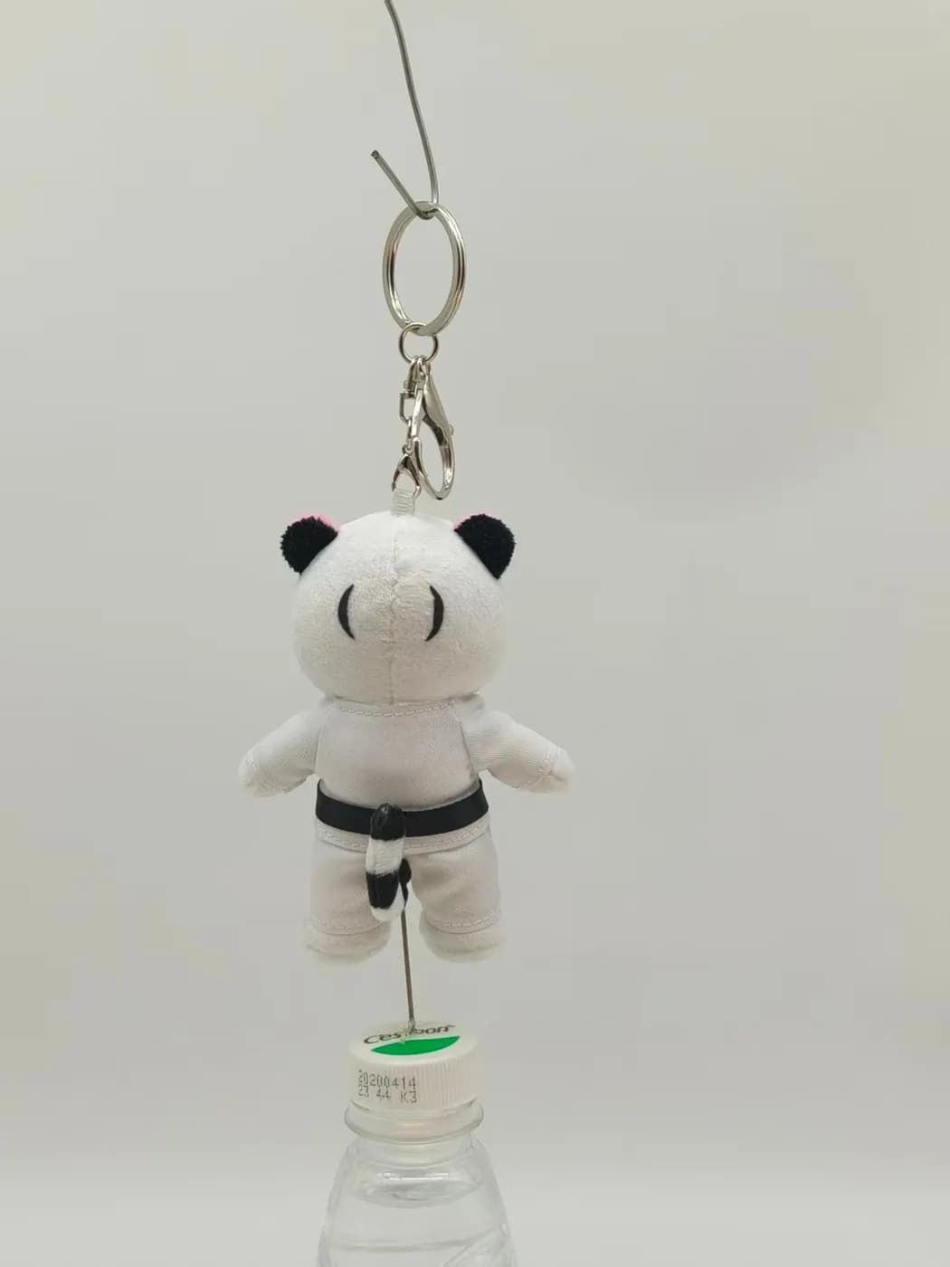 Panda plush charm on a split ring with an appliqué belt