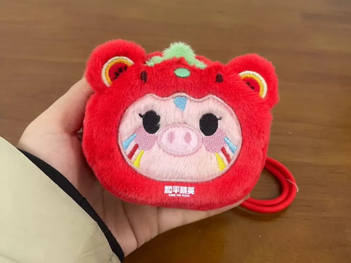 Red lion-hood coin purse charm with an appliqué pig face