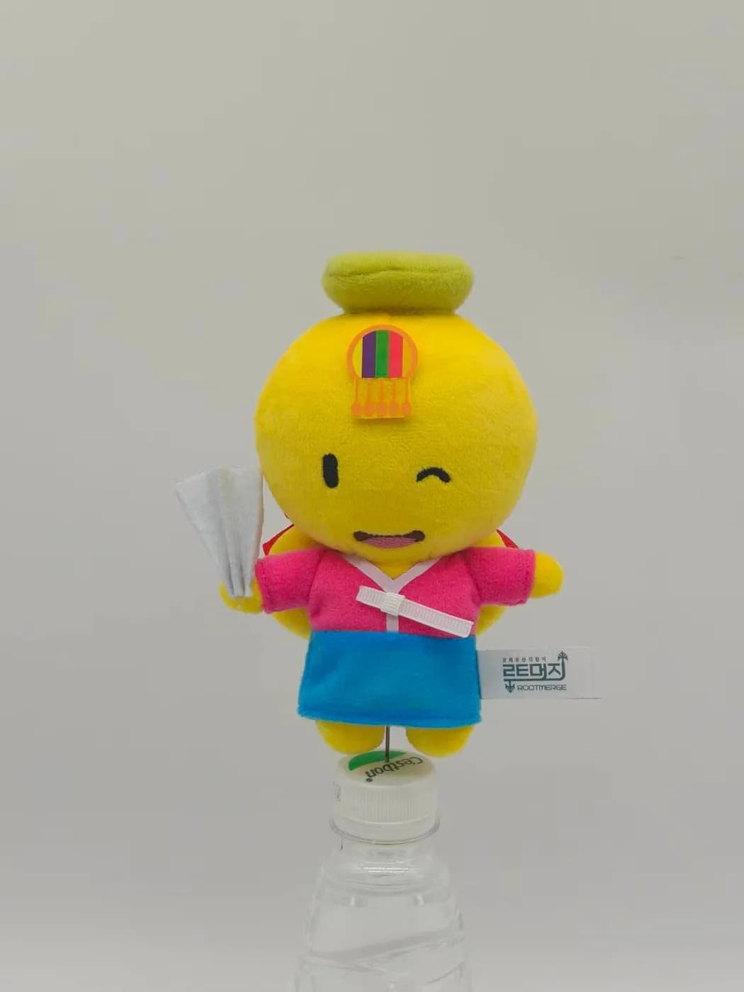 Yellow character mascot plush in a printed apron