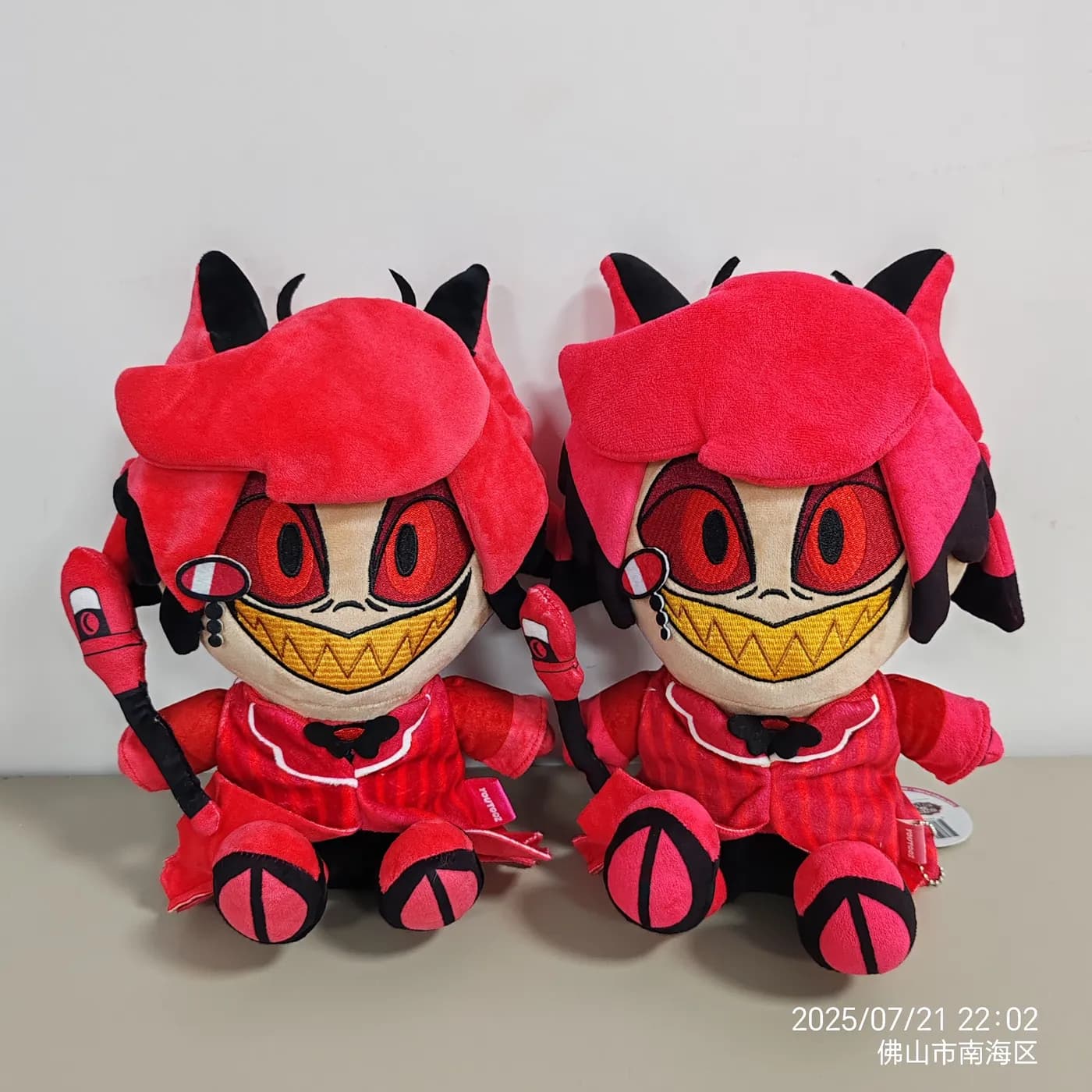Pair of red character plush toys with printed grins